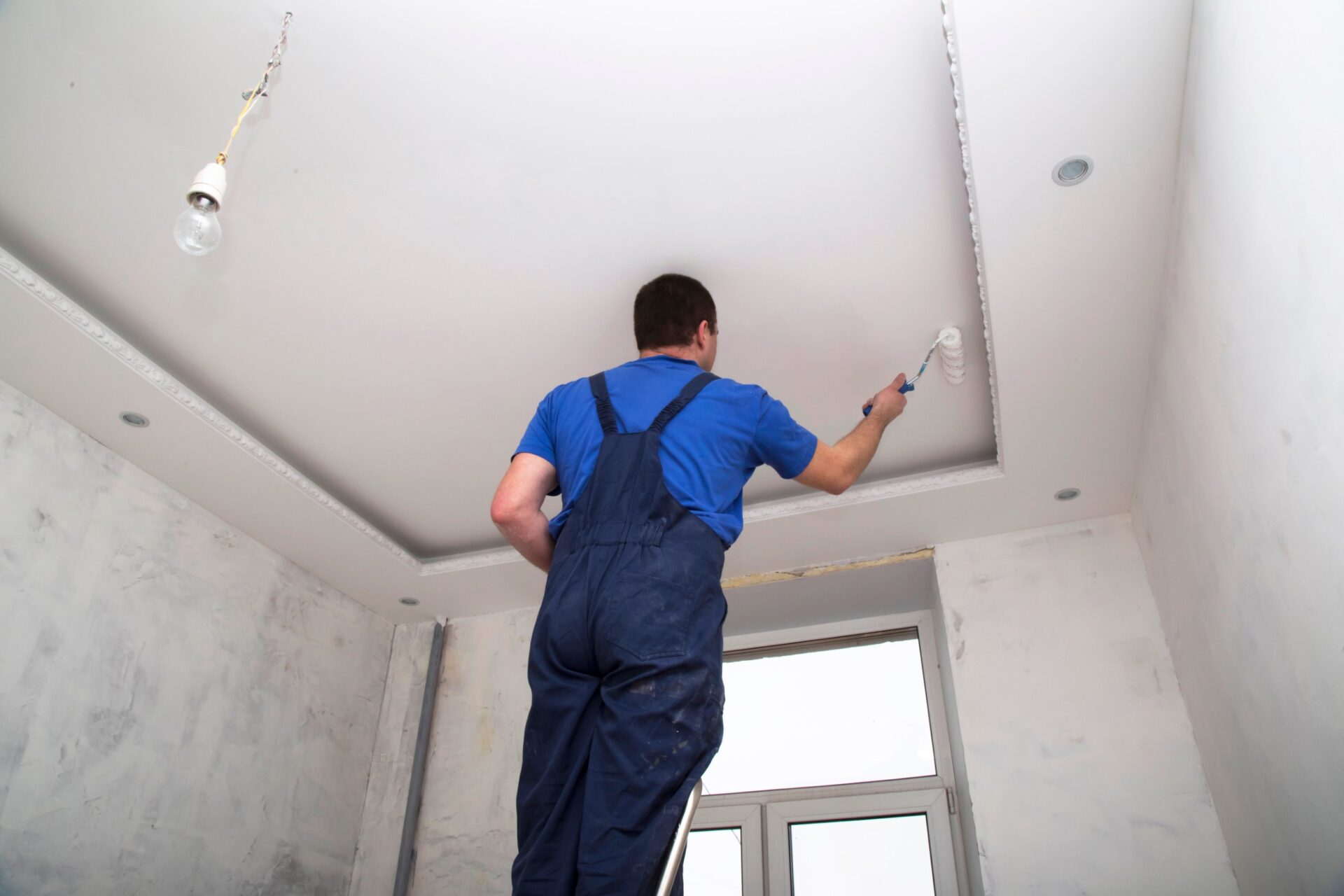 worker paints the ceiling worker paints the ceiling